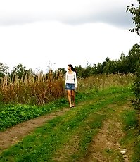 Cute brunette babe pisses up a storm in the field