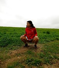 Barely legal brunette tinkling alone on a field